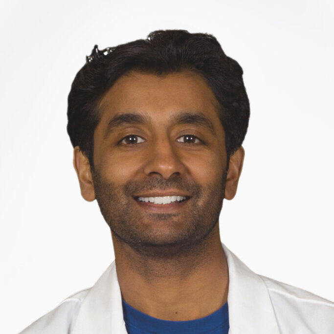 Headshot of Anand Satyapriya, MD, Co-Founder at Storilly. Anand is smiling, with white lab coat and blue scrubs.